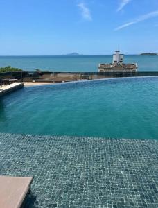 a large swimming pool with a view of the ocean at Apê Incrível nos Ingleses in Florianópolis +6 photos