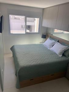 a bedroom with a large bed with a window at Apê Incrível nos Ingleses in Florianópolis