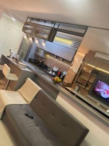 a living room with a couch and a kitchen at Apê Incrível nos Ingleses in Florianópolis