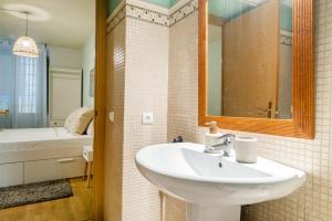 a bathroom with a sink and a mirror and a tub at Elena Apartments - Girona in Girona