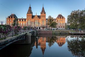 a large building with a bridge over a body of water at CampIn Hotel in Amsterdam