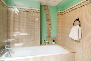 a bathroom with a white tub and a green wall at Elena Apartments - Girona in Girona