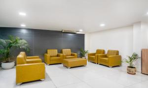 uma sala de espera com cadeiras amarelas e uma parede em Treebo Trend Emerald em Hyderabad