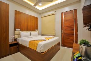 - une chambre avec un grand lit et une porte en bois dans l'établissement Hotel Ceasta, Beside US Consulate Hyderabad, Gachibowli, à Gundipet