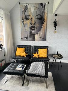 una sala de estar con un sofá negro y una pintura en Appartement 228 Bruinisse, en Bruinisse