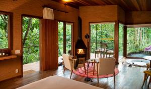 a living room with a fireplace and a table and chairs at Pousada Tijupá in Visconde De Maua