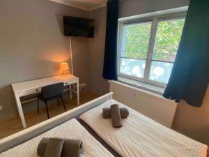 - une chambre avec 2 lits, un bureau et une fenêtre dans l'établissement Apartment in Potsdam-Babelsberg, à Potsdam