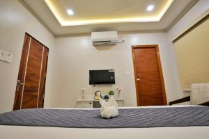 - une chambre avec un lit et une télévision dans l'établissement Hotel Ceasta, Beside US Consulate Hyderabad, Gachibowli, à Gundipet