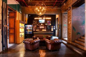 a lobby with two leather chairs and a bar at Socialtel Candelaria Bogotá in Bogotá