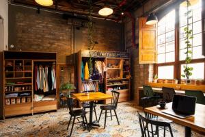 a dining room with a table and chairs and a brick wall at Socialtel Candelaria Bogotá in Bogotá
