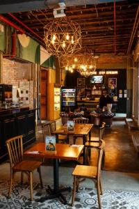 a restaurant with wooden tables and chairs and a bar at Socialtel Candelaria Bogotá in Bogotá