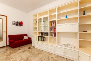 sala de estar con sofá rojo y estanterías en Flower apartment en Mantova