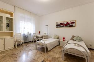 Habitación blanca con cama, mesa y sillas en Flower apartment en Mantova