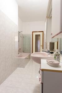 Baño blanco con 2 lavabos y bañera en Flower apartment en Mantova