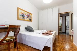 1 dormitorio con 1 cama blanca y 1 silla en Flower apartment en Mantova