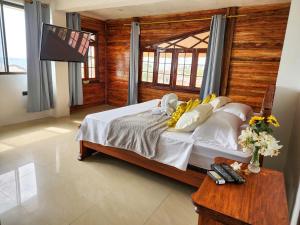 1 dormitorio con 1 cama grande y pared de madera en Hostal Poseidon, en Puerto Cayo