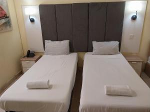 2 bedden in een kamer met witte lakens en kussens bij Whitestar Guesthouse in Salina