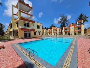 a villa with a swimming pool in front of a building at Greenwood Garden 3bedroom Mtwapa in Mombasa