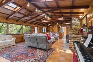 a living room with a couch and a piano at Spacious Serene Sanctuary- 14 min to Muir Woods in Mill Valley
