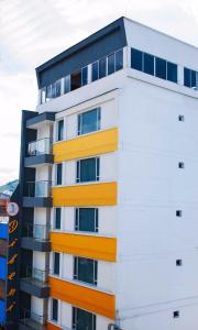 un edificio de apartamentos de color amarillo y blanco en Hotel Dibeni Pereira, en Pereira