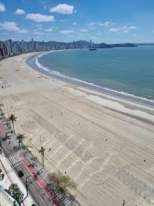 - une vue aérienne sur une plage avec des bâtiments et l'océan dans l'établissement Lindo apto Frente MAR tudo novinho 2suítes+garagem, à Balneário Camboriú