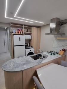 - une cuisine avec un comptoir en marbre et un évier dans l'établissement Lindo apto Frente MAR tudo novinho 2suítes+garagem, à Balneário Camboriú