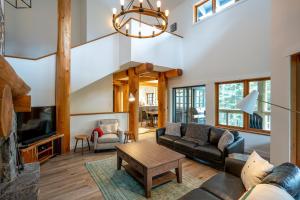 a living room with a couch and a table at Newly renovated 4-bed, bath ski-in, ski-out with fireplaces, private hot tub, and private garage! in Whistler