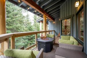 a screened in porch with a table and chairs at Newly renovated 4-bed, bath ski-in, ski-out with fireplaces, private hot tub, and private garage! in Whistler