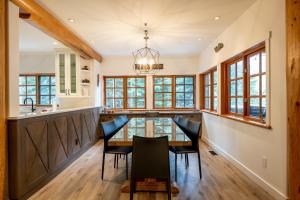 a kitchen with a dining room table and chairs at Newly renovated 4-bed, bath ski-in, ski-out with fireplaces, private hot tub, and private garage! in Whistler