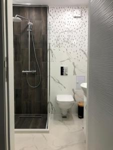 a bathroom with a shower and a toilet at Ultra Lux Studio Free Underground Parking in Pazardzhik