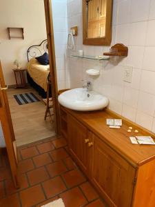 a bathroom with a sink and a bedroom with a bed at Melipal Schuss ARG41 in San Carlos de Bariloche