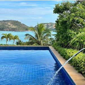 uma piscina com vista para o oceano em Casa de CINEMA 3 suites, 50m da Praia da Ferradura em Búzios