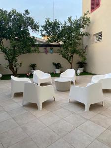 een groep witte stoelen en tafels op een patio bij B&B IL CICLISTA in Palombaro