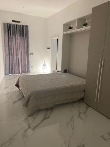 um quarto com uma cama grande e pisos em mármore em B&B IL CICLISTA em Palombaro