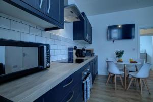 a kitchen with a counter and a table with chairs at Dundee - 1 Bed - Sleeps 4 - Free Parking in Dundee