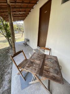 a wooden table and chairs in front of a building at Chalés Paradise - Casal in Serra do Cipo