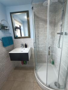uma casa de banho com um lavatório e um chuveiro em Grace's Place in Soham em Soham