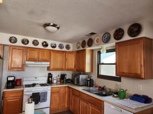 a kitchen with wooden cabinets and a white stove top oven at Buckboard House in Rio Rancho