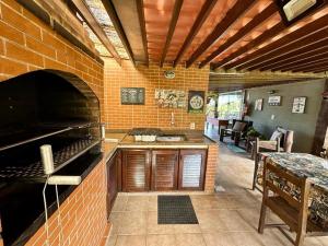 uma cozinha com uma parede de tijolos e um forno em Casa de CINEMA 3 suites, 50m da Praia da Ferradura em Búzios