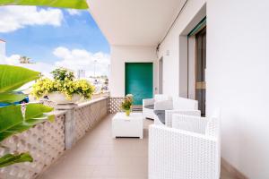 balcón con sillas blancas y puerta verde en Casa Dante, en Campomarino