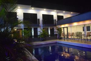 a house with a swimming pool at night at Hotel RITZZ in Paramaribo