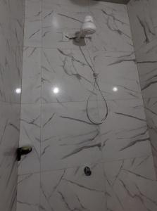 a shower with a white marble wall at Vila Coqueiro - Moitas in Amontada
