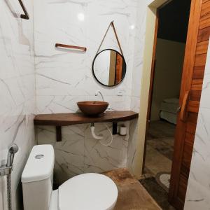 a bathroom with a toilet and a mirror at Vila Coqueiro - Moitas in Amontada