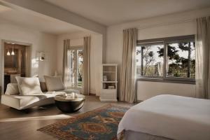 a bedroom with a bed and a couch and a window at Yria Island Boutique Hotel & Spa in Parasporos