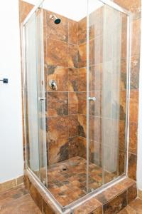 a shower with a glass door in a bathroom at Precious Paradise Ushaka in Durban