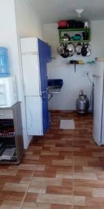 uma cozinha com um frigorífico branco e piso em madeira em Villa D Mariscos em Paripueira