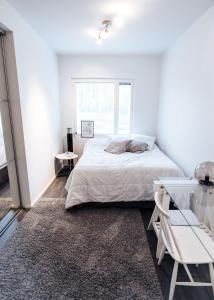 a white bedroom with a bed and a glass table at Apartment next to Ounasvaara and city centre in Rovaniemi