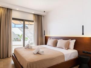 - une chambre avec un grand lit et 2 serviettes dans l'établissement Villa Evi, à Mykonos
