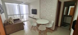 a living room with a white table and chairs at Wave Itapoã 702 Sul - Praia de Itapoã - Beverly Hills, comércio, piscinas panorâmicas, minimercado e lavanderia in Vila Velha