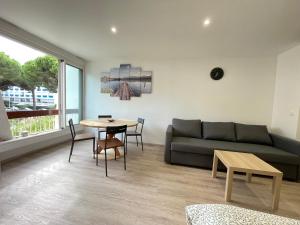 a living room with a couch and a table at cosy douillet la grande motte in La Grande-Motte